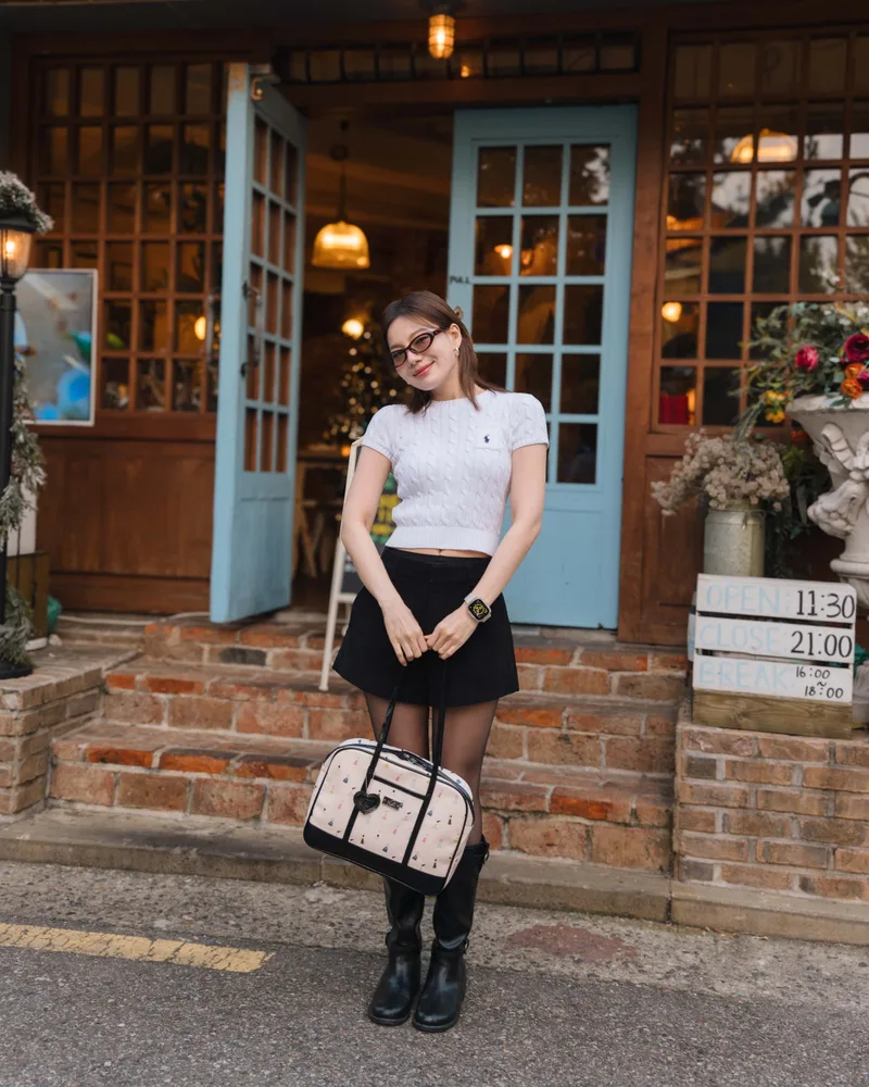 นางแบบยืนถือกระเป๋า The Carry Tote ลาย Little Girls หน้าร้านพาสต้าสไตล์วินเทจ