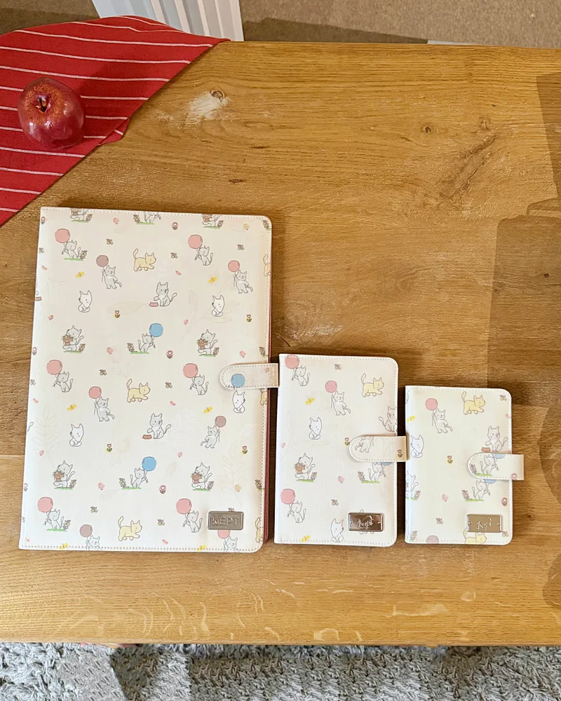 เล่มเก็บเอกสาร Deed Holder ลาย Happy Puppy วางเรียง 3 ขนาดบนโต๊ะไม้